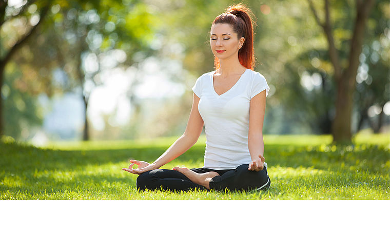 Eine Frau macht Yoga im Park. Link zu Angeboten im Programmbereich "Gesundheits- und Ernährungsbildung"