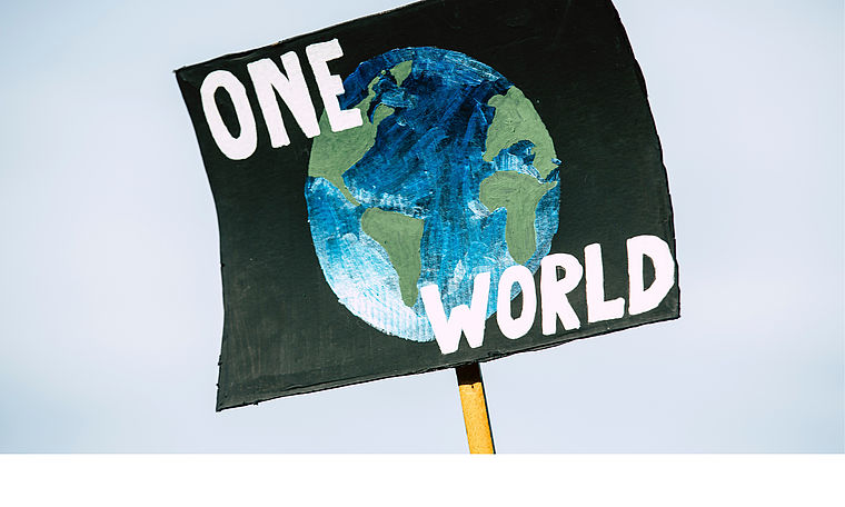 Ein Plakat mit einer Weltkugel auf der "Eine Welt" steht. Link zu Angeboten im Programmbereich "Mensch, Gesellschaft & Umwelt"